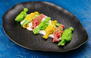 Chinese colourful steamed dumplings on black plate photo