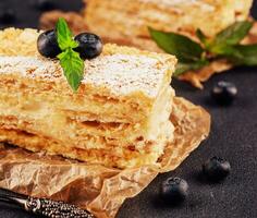 horneado pastel Napoleón, milhojas adornado con arándano y menta foto