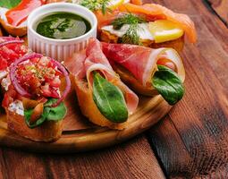 Different bruschetta on a wooden board photo