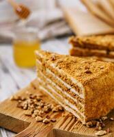 Slice of sweet honey cake on wooden board photo