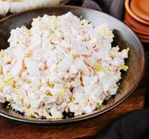 Salad with corn, crab sticks, cucumbers, eggs and mayonnaise photo