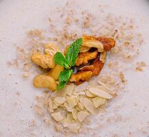 Homemade oatmeal flakes porridge with nuts photo