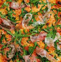 Prosciutto pizza or pinza with arugula photo