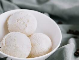 Vanilla ice cream balls on white bowl photo