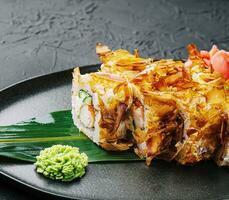 Sushi bonito roll on a dark plate photo