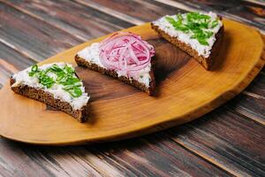 pieces of bread with delicious lard with red and green onions photo