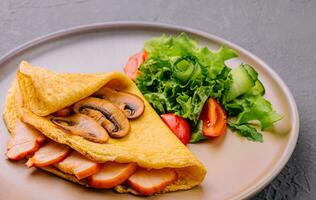 Thin delicious pancake with ham and mushrooms photo