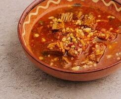 Spicy goulash soup with paprika on stone photo