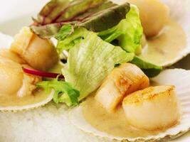 Seared scallops shell with butter and lettuce photo