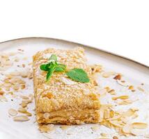 Napoleon Cake with almond on a white plate photo