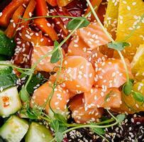 Poke bowl with salmon, cucumber, pepper and orange photo