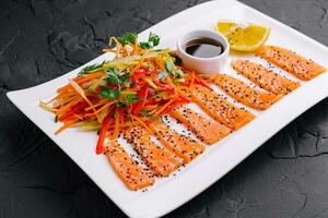 Salmon Slices with Carrot and Pepper Salad and Soy Sauce - Asian Cuisine photo