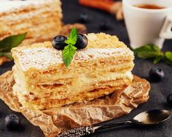 horneado pastel Napoleón, milhojas adornado con arándano y menta foto