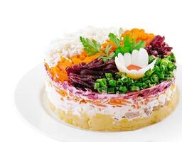Layered salad with beet, herring, carrots and potatoes on plate photo