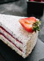 Piece of strawberry cheesecake on black board photo