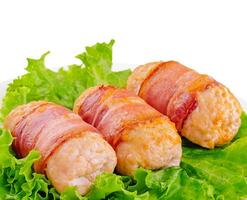 Pork cutlets wrapped in bacon on white photo