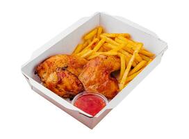 Fried chicken legs with french fries in paper box photo