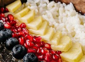 bowl of rice, pineapple, pomegranate and blueberries photo