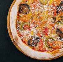 vegan pizza with roasted vegetables on wooden board photo