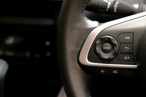 Control switch on the steering wheel. Settings and sound adjustment buttons.  close-up view photo