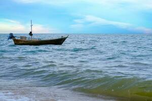 A small fishing boat floating, in the evening sea. photo