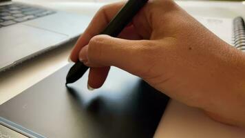 Closeup of a hand working with a pencil for a graphics tablet video