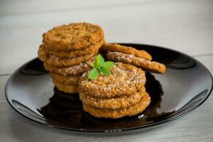 cooked sweet oatmeal cookies on wooden table photo