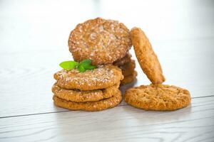 cooked sweet oatmeal cookies on wooden table photo