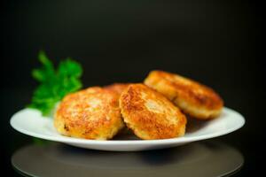 Cooked fried fish cutlets in a plate with herbs. photo