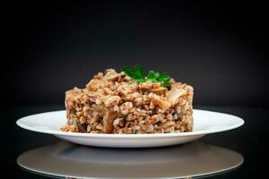 cooked buckwheat boiled with mushroom filling in a plate photo