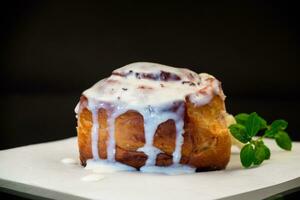 cooked baked sweet cinnabon with cream on black background photo
