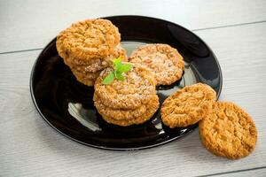 cooked sweet oatmeal cookies on wooden table photo