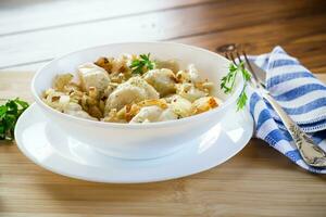 Ukrainian Vareniky or Pierogi stuffed with potato and mushrooms, served with fried onion. photo