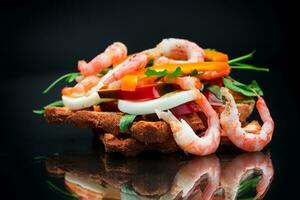 cooked sandwich with shrimp, eggs, pepper and greens photo