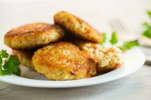 Cooked fried fish cutlets in a plate with herbs. photo