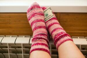 Feet in warm winter socks warm up on the radiator. photo