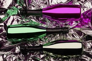 three different bottles of champagne on foil background photo