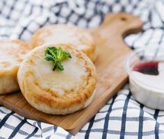 Cottage cheese pancakes on board close up photo