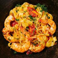 Italian pasta with shrimps in bowl photo