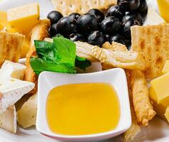 Different types of cheese on a white plate photo