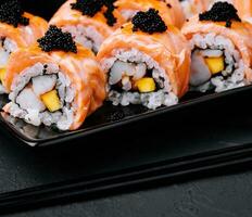 Sushi roll with fried salmon, shrimp and black caviar photo