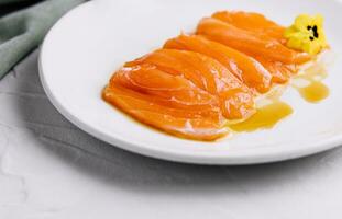 Chopped fresh salmon fillet on white plate photo