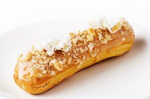 Caramel eclair on white plate isolated photo