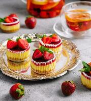 Mini strawberry cheesecake in muffin forms photo