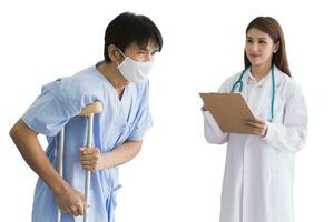 Professional Asian woman doctor standing check walking of male patient who wear face mask while he use walker to support stand symptom into clipboard in hospital while isolated on white background. photo