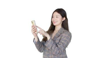 Young Asian professional woman with black long hair wearing plaid suit while she acts enjoy with success of work using smartphone while isolated on white background. photo