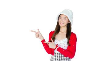 Beautiful Asian woman who wears red coat and white hat as santy girl acts her hand to present something while isolated on white background. photo