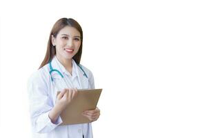 Professional beautiful young Asian woman doctor working at hospital. She wear white robe and stethoscope and hold clipboard in her hands while isolated on white background. photo