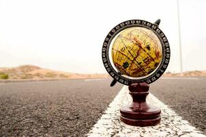 a globe is sitting on the end of a road photo