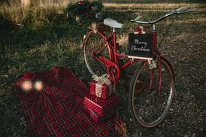rojo bicicleta con Navidad regalos y algunos linternas al aire libre foto
